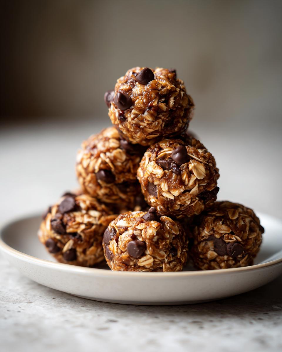 A stack of 5 ingredient energy balls made with oats and chocolate chips on a white plate.