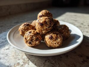 A pile of 5 ingredient energy balls made with oats and chocolate chips on a white plate.