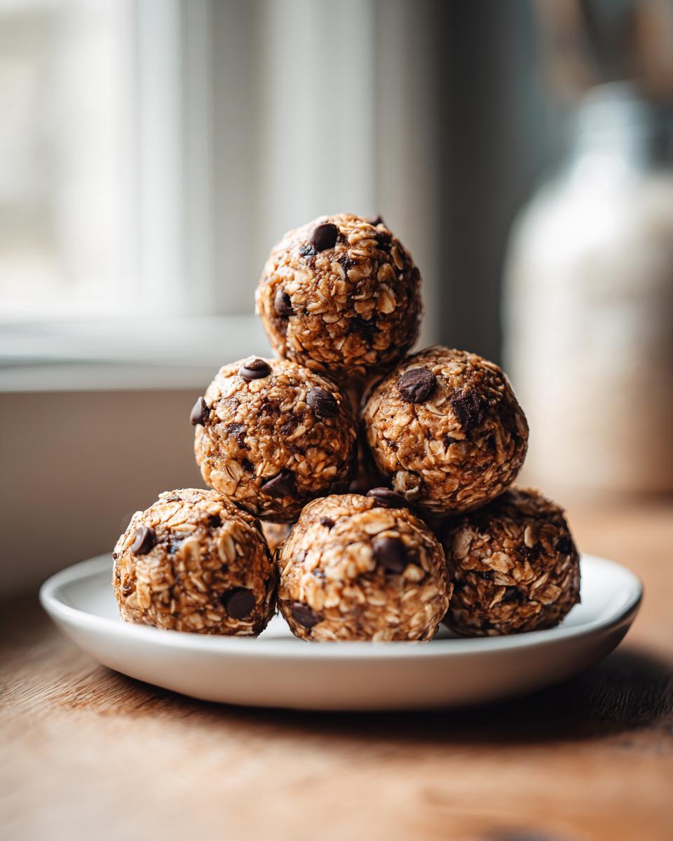 A stack of 5 ingredient energy balls with chocolate chips on a white plate, perfect for a 120 cal snack.