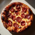 A close-up of a perfectly baked homemade pepperoni pizza with a chewy crust and melted cheese.