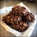 A close-up of a pile of no bake oatmeal cookies, showcasing their rich chocolate color and texture.