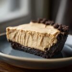 A delicious slice of no bake peanut butter pie with a chocolate cookie crust.