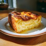 A delicious slice of Overnight French Toast Casserole, golden brown and drizzled with syrup.