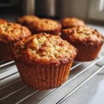 Close-up of golden-brown pumpkin banana muffins cooling on a wire rack.