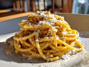 A close-up of a steaming plate of authentic Spaghetti Carbonara, generously topped with Pecorino Romano cheese and black pepper.