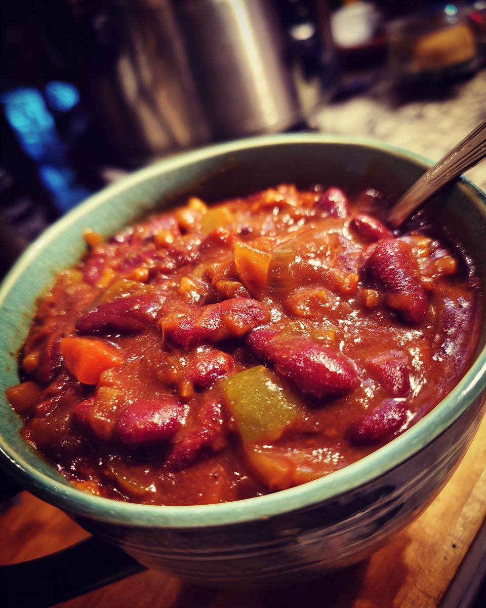 A close-up of a bowl filled with delicious vegetarian chili, featuring kidney beans, diced tomatoes, and vegetables.