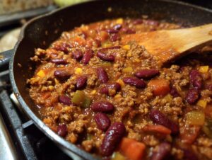 Close-up of a rich and savory vegetarian chili simmering in a cast iron skillet, with kidney beans and vegetables.
