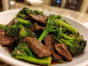 Close-up of tender slices of beef and vibrant green broccoli florets coated in a savory sauce.