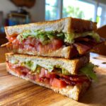 A perfectly constructed BLT sandwich with thick-cut bacon, ripe tomatoes, and crisp lettuce on toasted bread.