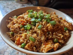 A close-up bowl of flavorful 20-Min Chicken Fried Rice, garnished with chopped green onions.