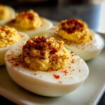 Close-up of creamy deviled eggs topped with paprika, ready to serve.