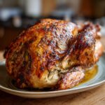 A beautifully golden-brown roast turkey, glistening with juices and herbs, ready to serve.