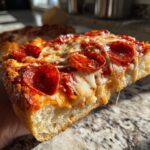 A close-up shot of a slice of pepperoni pizza, showcasing melted cheese and crispy pepperoni.
