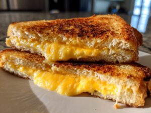 A close-up of a perfectly grilled cheese sandwich, cut in half, showcasing gooey melted cheese oozing out.