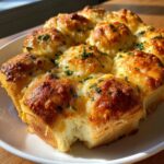 Close-up of cheesy, golden-brown hawaiian roll garlic bread topped with parsley.