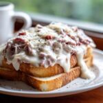 Close-up of delicious chipped beef on toast smothered in white gravy and cheese.