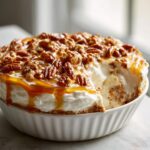 A creamy, no-bake pecan pie dip topped generously with pecans and caramel sauce.