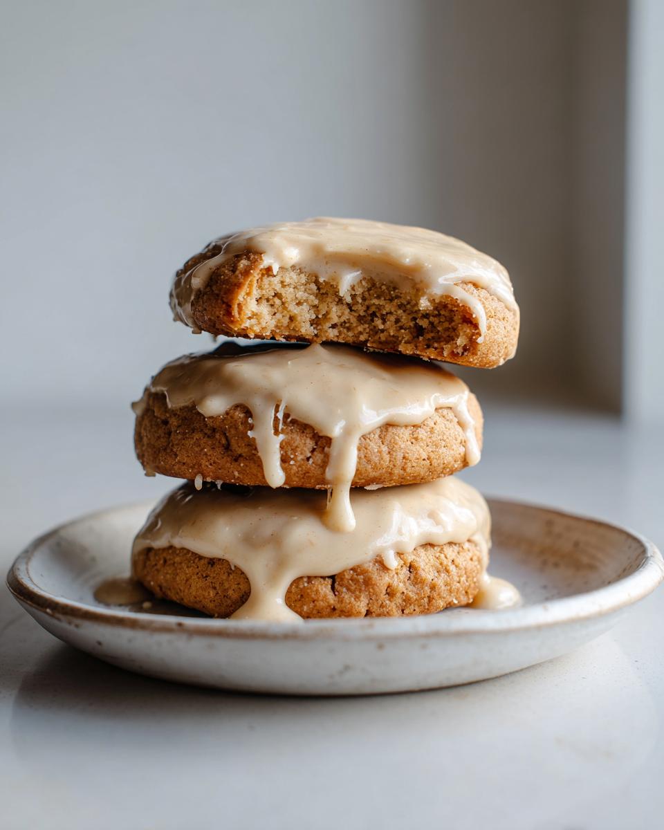 A stack of three soft maple cookies generously topped with dripping brown butter icing.