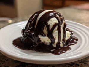 A scoop of vanilla ice cream and brownie covered in rich, silky chocolate sauce recipe.