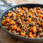 Close-up of a savory sweet potato skillet mixture with ground meat, black beans, and corn.