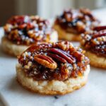 Close-up of a delicious pecan pie cookie with a buttery base and sticky pecan topping.