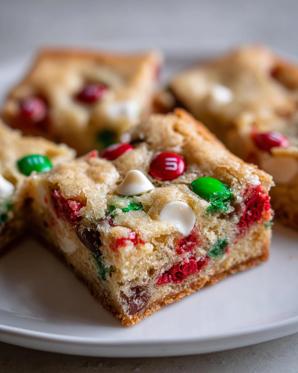 Close-up of a chewy Christmas cookie bars square loaded with red, green, and white M&M's and chocolate chips.