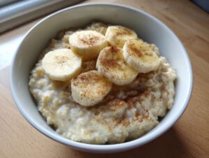 Close-up of creamy banana oatmeal topped with sliced bananas and a sprinkle of cinnamon.