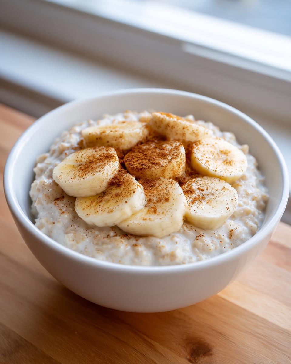 Close-up of creamy banana oatmeal topped with fresh banana slices and a dusting of cinnamon.