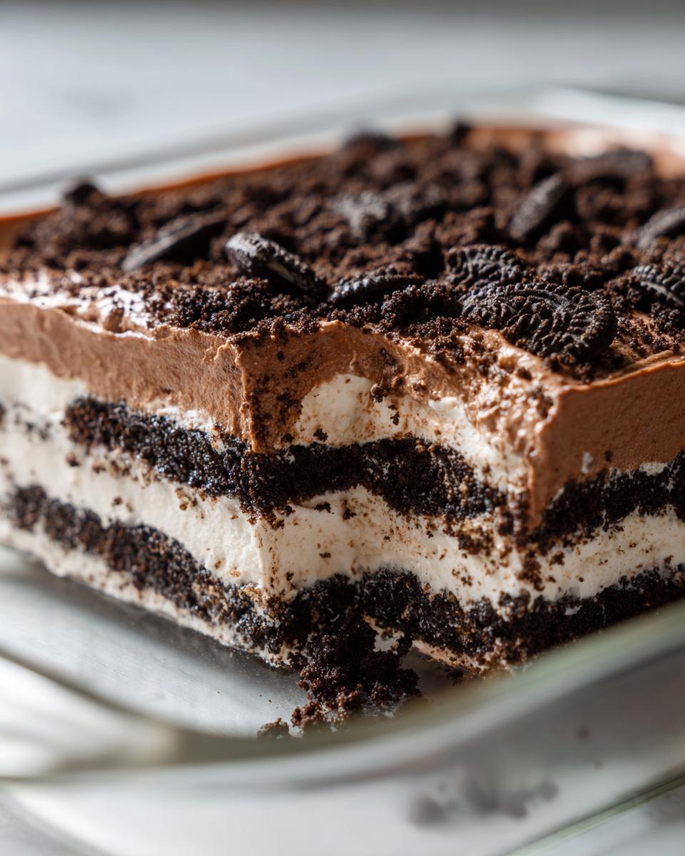 Close-up of a rich, layered Oreo dirt cake showing chocolate mousse, cream filling, and crushed Oreo topping.