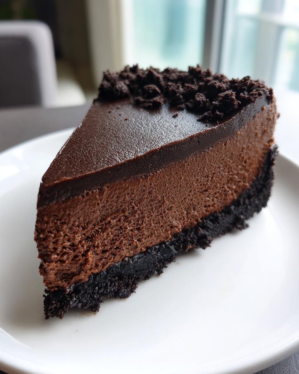A perfect slice of rich chocolate cheesecake featuring a dark crust, creamy filling, and chocolate crumb topping.