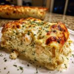 A generous slice of creamy seafood lasagna topped with bubbly, browned cheese and fresh parsley.
