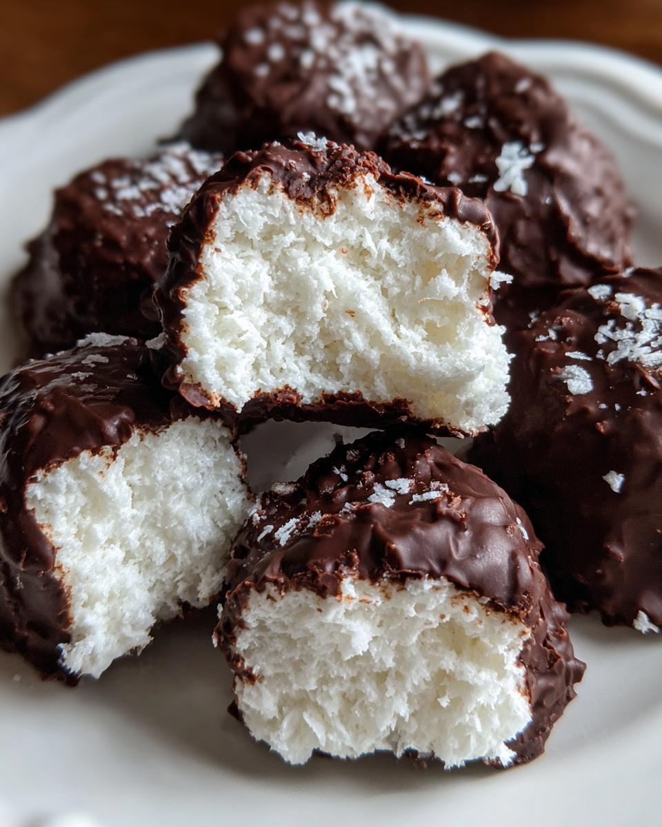 Close-up of chocolate-dipped coconut mounds, showing the fluffy white interior of the cool whip candy.