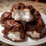 Close-up of chocolate-dipped coconut mounds, showing the white, fluffy cool whip candy interior.