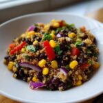 Close-up of a vibrant cilantro lime quinoa salad featuring black beans, corn, red pepper, and red onion.