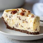 A generous slice of creamy, no-bake Million Dollar Pie with a dark crust, topped with pecans.