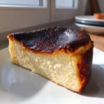 A perfect slice of Basque burnt cheesecake showing its deeply caramelized top and creamy interior.