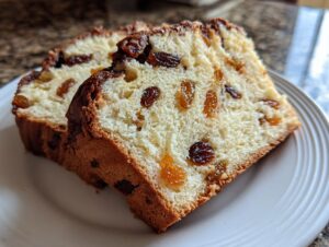 Close-up of two thick slices of soft raisin bread showing the fluffy interior and dark raisins.