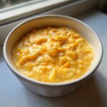 Close-up of a creamy bowl filled with thick, cheesy orange chunks, representing the amazing 1-pot cheese soup.