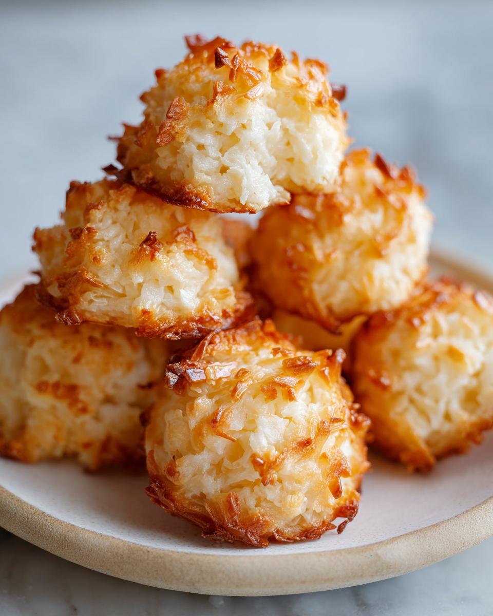 A stack of golden brown, chewy coconut macaroons recipe with sweetened condensed milk, showing toasted edges.