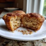 A gluten free churro cupcake cut in half showing the moist, crumbly texture and cinnamon sugar topping.