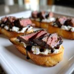 Close-up of a perfectly cooked steak crostini topped with creamy cheese and drizzled with balsamic glaze.