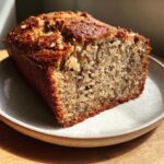 Close-up of a slice of moist cottage cheese banana bread almond flour loaf with a golden-brown crust.