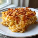 A close-up of a serving of french onion chicken noodle casserole with a crispy, golden-brown topping.