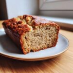 Close-up of a moist slice of high protein cottage cheese banana bread on a light plate.